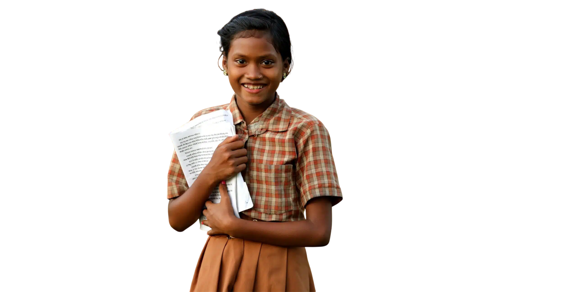 A schoolgirl in a checked uniform smiling as she holds her books and worksheets.